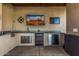 The covered outdoor kitchen features stainless steel appliances, ample counter space, and a built-in grill at 5511 N 128Th Dr, Litchfield Park, AZ 85340