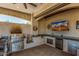 This spacious outdoor kitchen has granite counters, stainless appliances, and a sink for outdoor entertaining at 5511 N 128Th Dr, Litchfield Park, AZ 85340