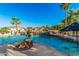 Beautiful pool with waterfall feature, slide, and hot tub surrounded by lush landscaping and palm trees at 5511 N 128Th Dr, Litchfield Park, AZ 85340