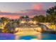 Beautiful rock waterfall feature with a slide leading into the pool with a colorful sky backdrop at 5511 N 128Th Dr, Litchfield Park, AZ 85340