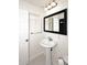 Bright bathroom with a pedestal sink, black framed mirror and built-in shelving at 5634 N 39Th Ave, Phoenix, AZ 85019