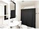 Bathroom with a pedestal sink, framed mirror, and shower with black curtain at 5634 N 39Th Ave, Phoenix, AZ 85019