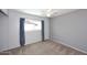 Simple bedroom with carpet, ceiling fan, and a window with blue curtains at 5634 N 39Th Ave, Phoenix, AZ 85019