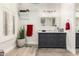 Bathroom showcasing gray vanity with marble top, updated lighting, and shuttered windows providing natural light at 621 W Desert Ave, Gilbert, AZ 85233