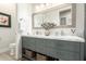 Double sink bathroom vanity with grey cabinets and a marble countertop with decoratively framed mirror and artwork at 621 W Desert Ave, Gilbert, AZ 85233