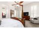Main bedroom features a four poster bed, ceiling fan, sitting area, and a view of the ensuite bathroom at 621 W Desert Ave, Gilbert, AZ 85233