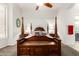 Bright main bedroom featuring a four poster bed, ceiling fan, and a decorative wood trunk at 621 W Desert Ave, Gilbert, AZ 85233