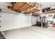 Clean garage featuring an epoxy floor, a garage door, overhead racks for storage, and a workout area at 621 W Desert Ave, Gilbert, AZ 85233