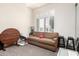 Comfortable living room with sofa and window shutters, next to an interesting wood table and baby swing at 621 W Desert Ave, Gilbert, AZ 85233