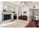 Comfortable living room with a fireplace, hardwood floors, a ceiling fan, and large windows at 621 W Desert Ave, Gilbert, AZ 85233
