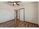 A small bedroom with wood floors, a ceiling fan, and access to an ensuite bathroom and a closet at 6602 E Heather Dr, Mesa, AZ 85215