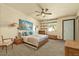 Cozy bedroom featuring warm lighting, a ceiling fan, and a peaceful view from the window at 6602 E Heather Dr, Mesa, AZ 85215