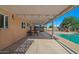 Relaxing covered patio featuring modern outdoor lighting, a dining set, and view of the sparkling pool at 6602 E Heather Dr, Mesa, AZ 85215