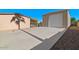 Backyard featuring a large detached garage/workshop and concrete parking pad with desert landscaping at 6602 E Heather Dr, Mesa, AZ 85215