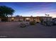 Charming single-story home featuring desert landscaping, cozy curb appeal, and ample natural light at dusk at 6602 E Heather Dr, Mesa, AZ 85215