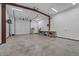Spacious garage/workshop area with a roll up garage door, work benches, and overhead lighting at 6602 E Heather Dr, Mesa, AZ 85215