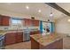 Updated kitchen boasts stainless steel appliances, granite countertops, island, and backyard pool view at 6602 E Heather Dr, Mesa, AZ 85215