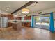 Open kitchen with stainless appliances, an island, tile floors, and access to the backyard and pool at 6602 E Heather Dr, Mesa, AZ 85215