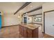 Open concept living room has beam ceilings, granite island, tile floor, and access to other rooms at 6602 E Heather Dr, Mesa, AZ 85215