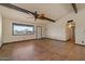 A spacious living room with tile floors, beam ceilings, and a large window bringing in natural light at 6602 E Heather Dr, Mesa, AZ 85215