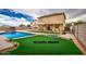 Virtually staged backyard featuring a pool, hot tub, and artificial grass at 703 N Redwood Ln, Buckeye, AZ 85326