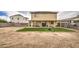 Spacious backyard featuring a covered patio, artificial grass, block wall, and a fire pit for outdoor relaxation at 703 N Redwood Ln, Buckeye, AZ 85326