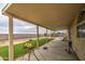View of the backyard with artificial grass and a covered patio for outdoor dining at 703 N Redwood Ln, Buckeye, AZ 85326