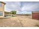 Large backyard with a covered patio, a separate storage shed, and open space for outdoor activities at 703 N Redwood Ln, Buckeye, AZ 85326