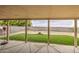View of the covered patio overlooking the backyard featuring artificial grass and gravel at 703 N Redwood Ln, Buckeye, AZ 85326