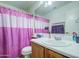 Functional bathroom features pink shower curtain, sink, and mirror, offering a clean and practical space at 703 N Redwood Ln, Buckeye, AZ 85326
