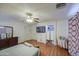 Large bedroom with ceiling fan, hardwood floors, and a television mounted to the wall at 703 N Redwood Ln, Buckeye, AZ 85326