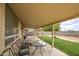 Cozy covered patio with outdoor furniture, perfect for relaxing and enjoying the backyard view at 703 N Redwood Ln, Buckeye, AZ 85326