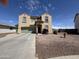 Spacious two-story home with a two-car garage and low-maintenance desert landscaping creating a welcoming curb appeal at 703 N Redwood Ln, Buckeye, AZ 85326