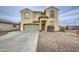 Home exterior featuring a two-car garage, desert landscaping, and a tiled front entry at 703 N Redwood Ln, Buckeye, AZ 85326