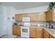 Traditional kitchen with wood cabinets, neutral countertops, and standard white appliances at 703 N Redwood Ln, Buckeye, AZ 85326