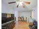 Open living room featuring light walls, wood floors, and an entertainment center under a ceiling fan at 703 N Redwood Ln, Buckeye, AZ 85326