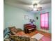 Comfortable living room featuring a piano, ceiling fan, and wood-look flooring at 703 N Redwood Ln, Buckeye, AZ 85326