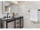 Modern bathroom features a wood grain vanity with double sinks and luxurious marble tile backsplash at 7232 W Sunnyside Dr, Peoria, AZ 85345