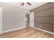 A bedroom featuring wood floors, modern ceiling fan, and an accent wall, creating a stylish space at 7232 W Sunnyside Dr, Peoria, AZ 85345