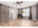 An owner's bedroom features vinyl flooring, barn door to the bathroom, and a view to the backyard pool at 7232 W Sunnyside Dr, Peoria, AZ 85345