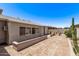 A private backyard with a brick patio, showcasing a low retaining wall and easy-care desert landscaping at 7904 E Madero Ave, Mesa, AZ 85209
