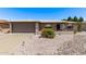 Charming single-story home featuring desert landscaping, gray brick accents and covered front entry at 7904 E Madero Ave, Mesa, AZ 85209