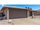 Exterior of home with a gray garage door with a long driveway and some trash cans at 7904 E Madero Ave, Mesa, AZ 85209