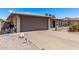 Exterior of home with a gray garage door with a long driveway and desert landscaping at 7904 E Madero Ave, Mesa, AZ 85209