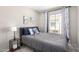 Comfortable bedroom with gray comforter, side table, and a sunny window view at 7915 E Keim Dr, Scottsdale, AZ 85250