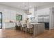 Open-concept kitchen with white cabinets, a large island with seating, and modern lighting fixtures at 8501 E Appaloosa Trl, Scottsdale, AZ 85258