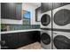 Laundry room showcasing dark cabinets, a white countertop, and a modern, stackable washer and dryer set at 8501 E Appaloosa Trl, Scottsdale, AZ 85258