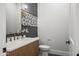 Stylish powder room with a patterned accent wall, a modern vanity, and black fixtures at 8501 E Appaloosa Trl, Scottsdale, AZ 85258