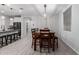 Dining area featuring a wood dining table, modern light fixture and nearby modern kitchen with island at 8737 E Nichols Ave, Mesa, AZ 85209