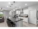 Modern kitchen with stainless steel appliances, white cabinets, island with seating, and pendant lighting at 8737 E Nichols Ave, Mesa, AZ 85209